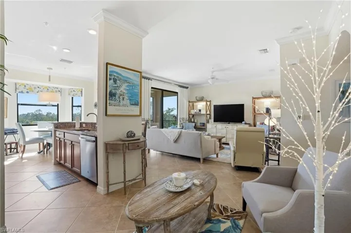 Living room with crown molding, ceiling fan, light tile patterned floors, and recessed lighting