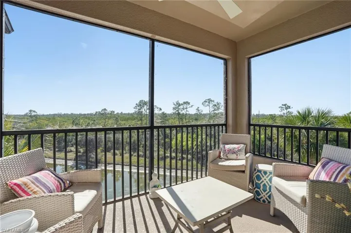 Sunroom / solarium with a balcony and a view of trees