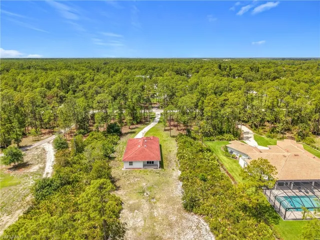 Property with a red tile roof and a surrounding wooded landscape