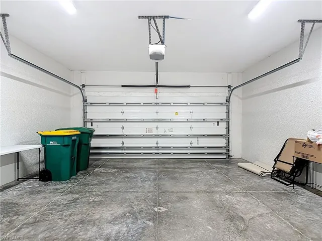 The property features a garage with a concrete floor, an automatic garage door opener, and overhead lighting