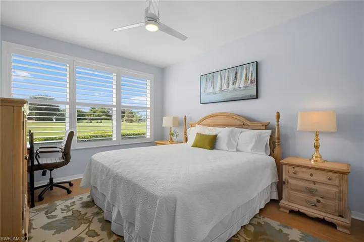 Bedroom featuring ceiling fan, light wood finished floors, and a desk