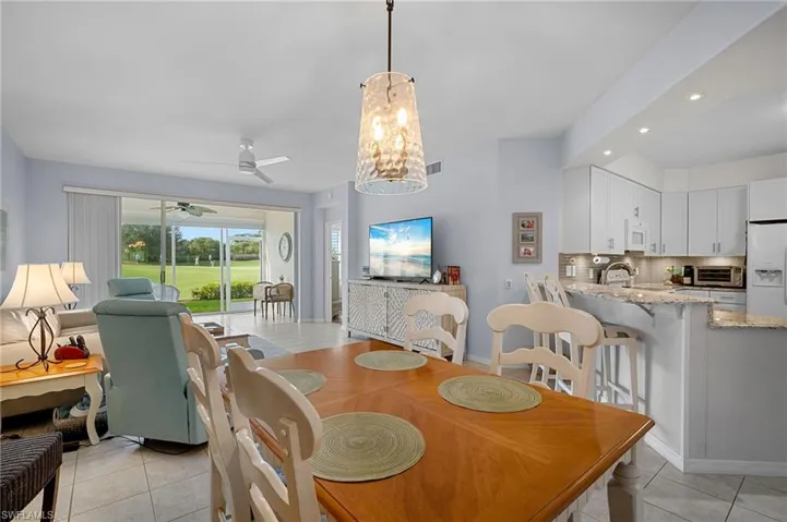 Dining room with light tile patterned floors, a chandelier, recessed lighting, and ceiling fan