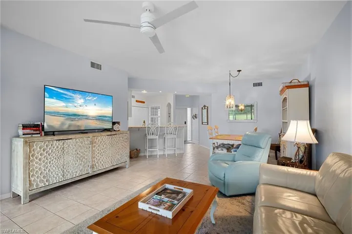 Living room featuring light tile patterned floors and a ceiling fan