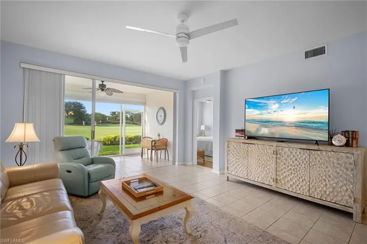 Living area with light tile patterned flooring and ceiling fan