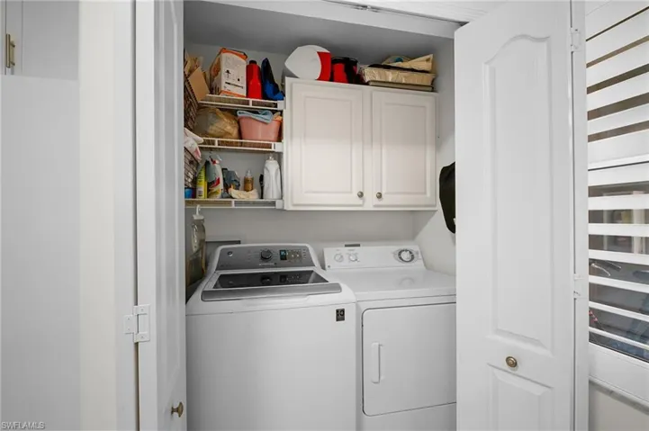 Washroom with cabinet space and washing machine and clothes dryer