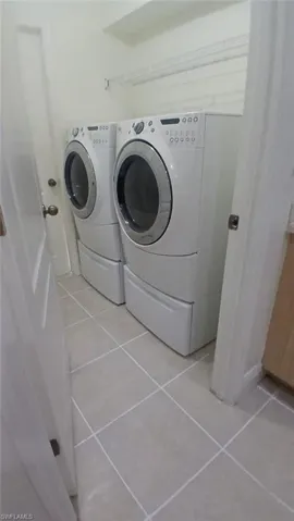Laundry room featuring independent washer and dryer and light tile patterned flooring