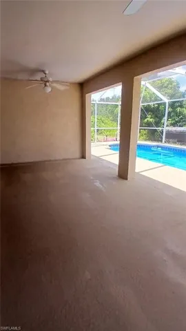 Outdoor pool with ceiling fan and a sunroom