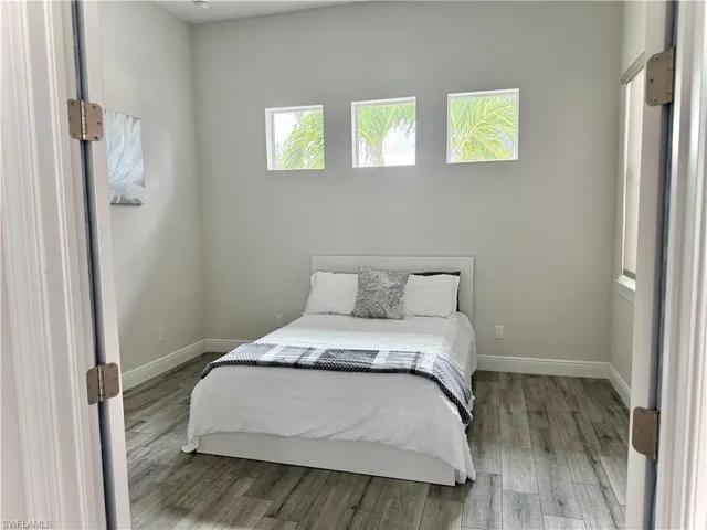 Bedroom featuring multiple windows and wood finished floors