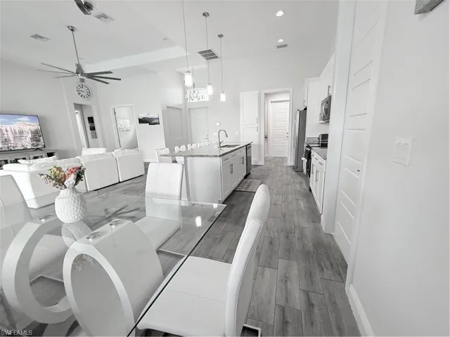 Dining area featuring a ceiling fan, dark wood-style flooring, and recessed lighting