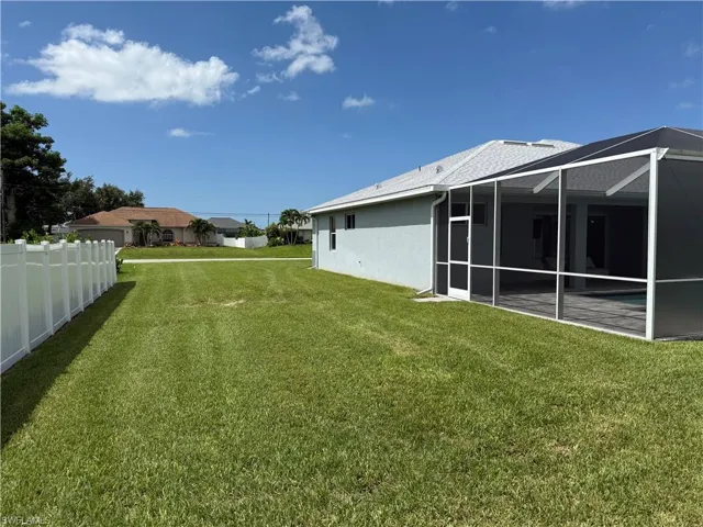 View of yard with glass enclosure and a patio area