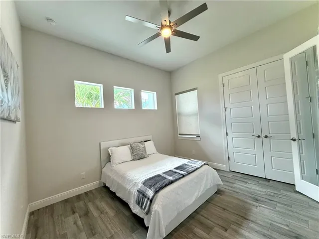 Bedroom with wood finished floors, a closet, and a ceiling fan