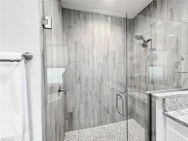 Ensuite bathroom featuring tile walls, a soaking tub, a wainscoted wall, ceiling fan, and recessed lighting