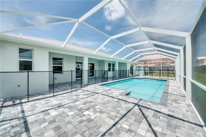 Swimming pool featuring a patio area and glass enclosure