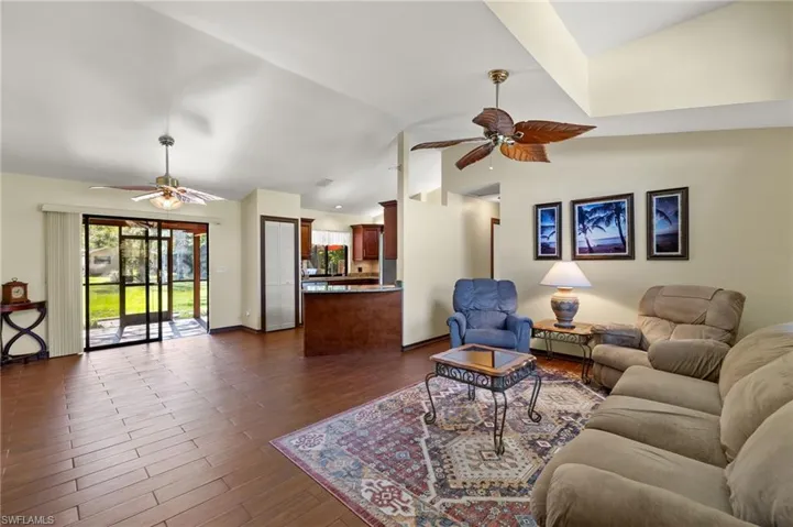 Living room with lofted ceiling and dark wood-type flooring