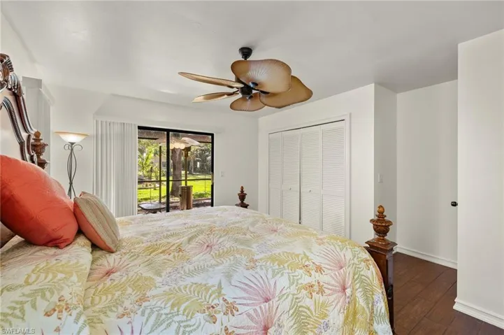 Bedroom with access to exterior, ceiling fan, a closet, and dark wood-type flooring