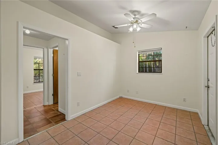 Tiled spare room featuring ceiling fan and lofted ceiling
