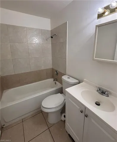 Bathroom with vanity, shower / tub combination, and light tile patterned floors