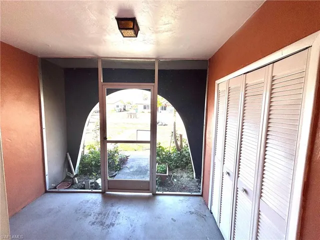 Doorway to outside with unfinished concrete floors
