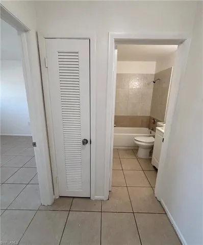 Bathroom with vanity, light tile patterned flooring, shower / tub combination, and a closet