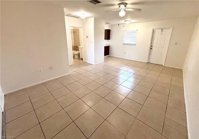 Spare room with a ceiling fan and light tile patterned flooring