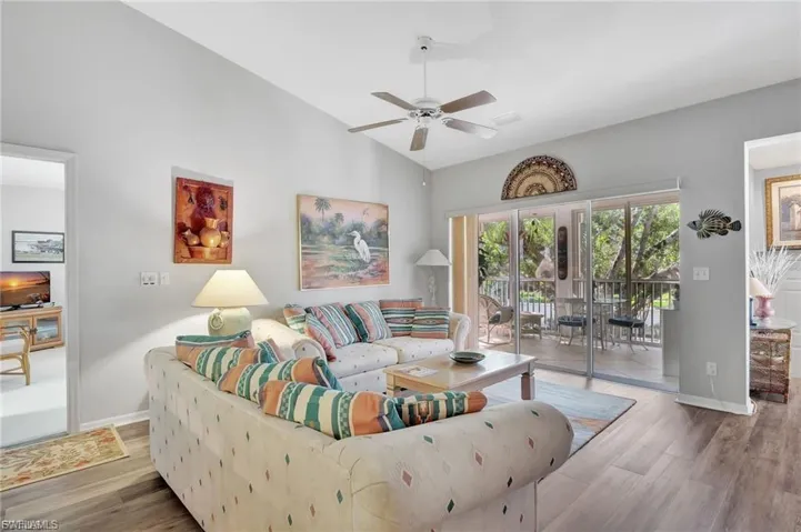 Living area with wood finished floors, lofted ceiling, and a ceiling fan