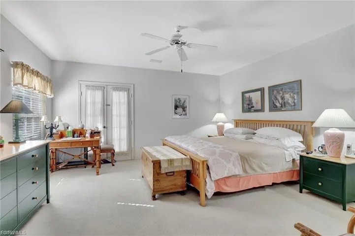 Bedroom featuring light carpet, a desk, and ceiling fan