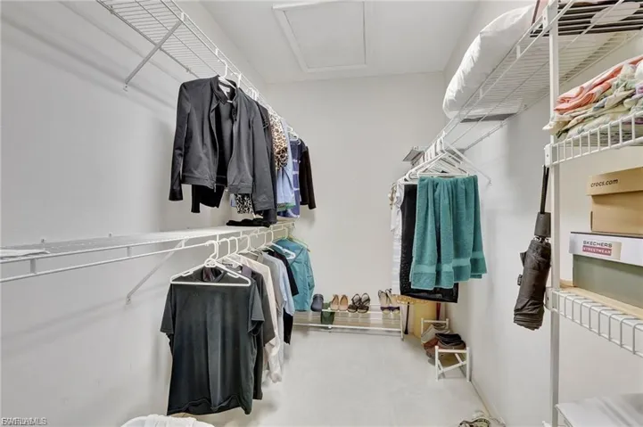 Walk in closet featuring attic access and carpet flooring