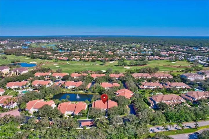 View of property location featuring a nearby body of water, a golf course, and nearby suburban area
