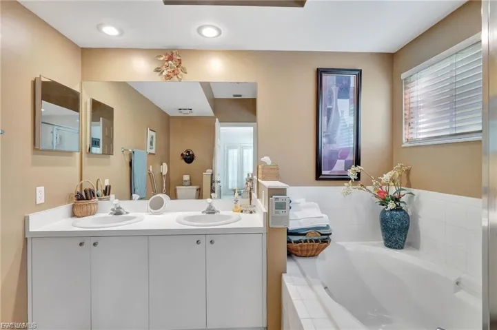 Full bath featuring double vanity and a garden tub