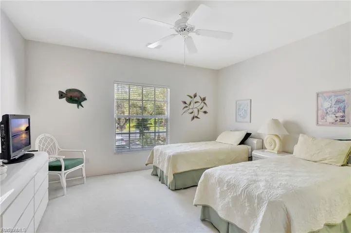 Bedroom with light colored carpet and a ceiling fan