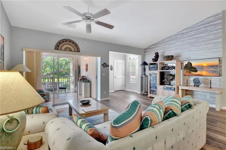 Living area with wood finished floors, vaulted ceiling, and a ceiling fan