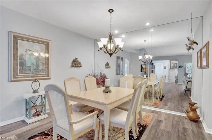 Dining room with light wood-style flooring, recessed lighting, and a chandelier