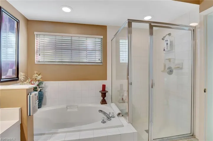 Full bathroom featuring vanity, a bath, a stall shower, healthy amount of natural light, and recessed lighting
