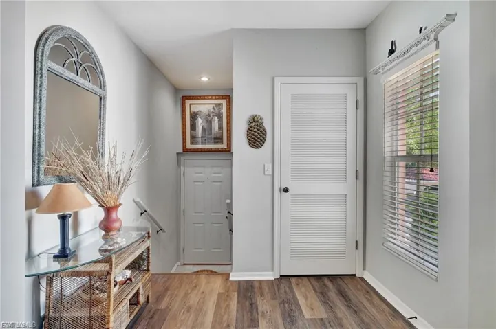 Foyer entrance with wood finished floors and recessed lighting