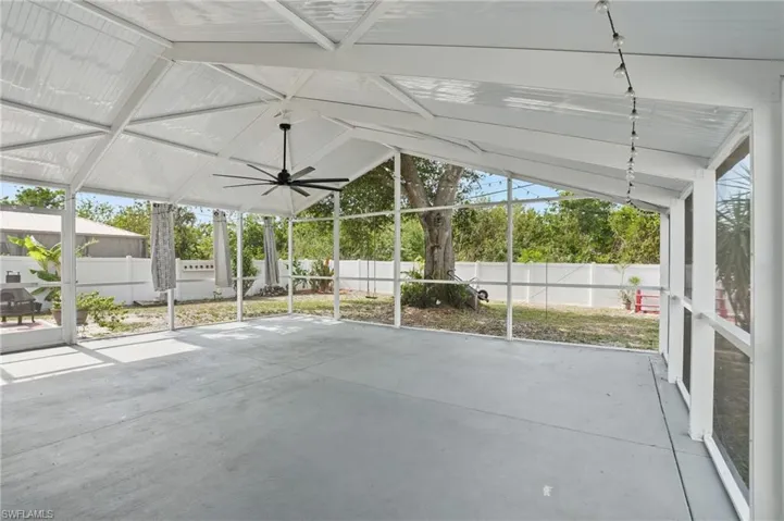 Unfurnished sunroom featuring vaulted ceiling and a ceiling fan