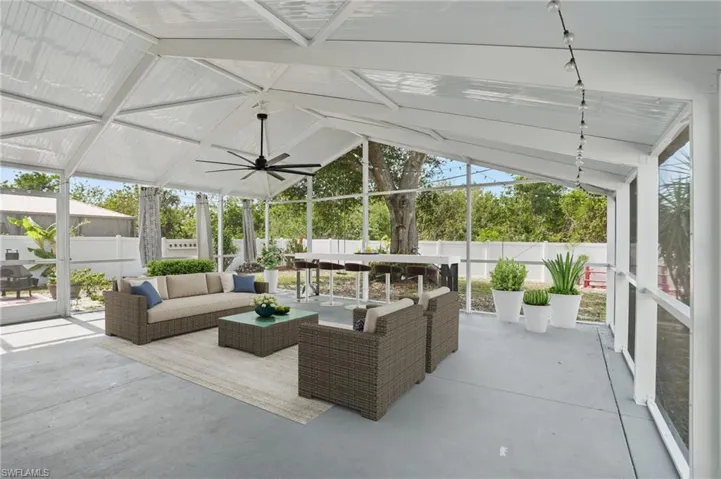 Sunroom with lofted ceiling, ceiling fan, a patio, and an outdoor hangout area
