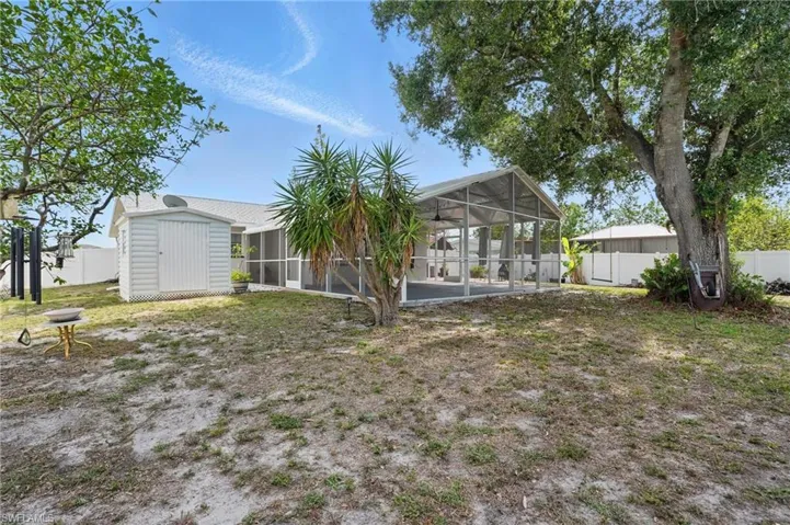 Back of property featuring a sunroom, a fenced backyard, and a lanai