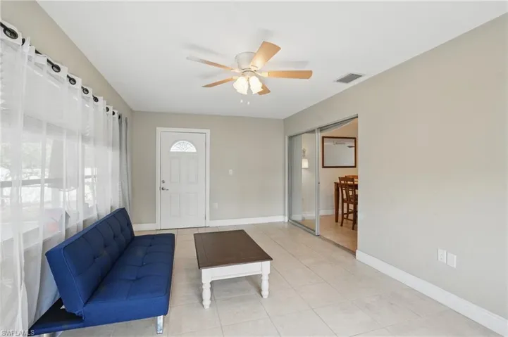 Unfurnished living room featuring ceiling fan and tile patterned flooring