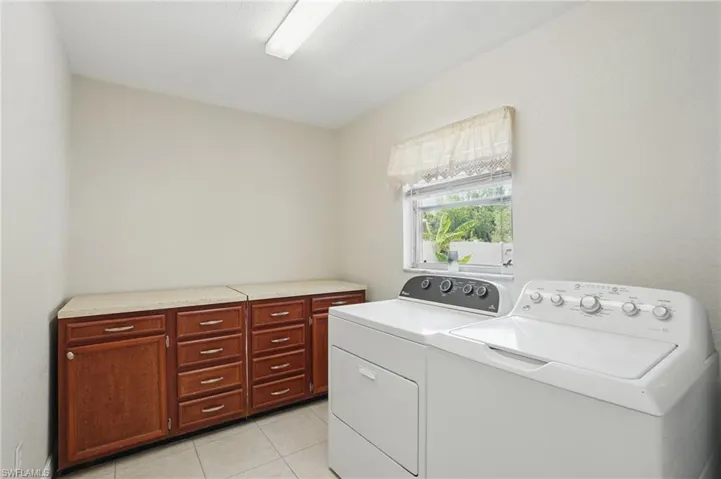 Washroom featuring light tile patterned floors and washing machine and dryer
