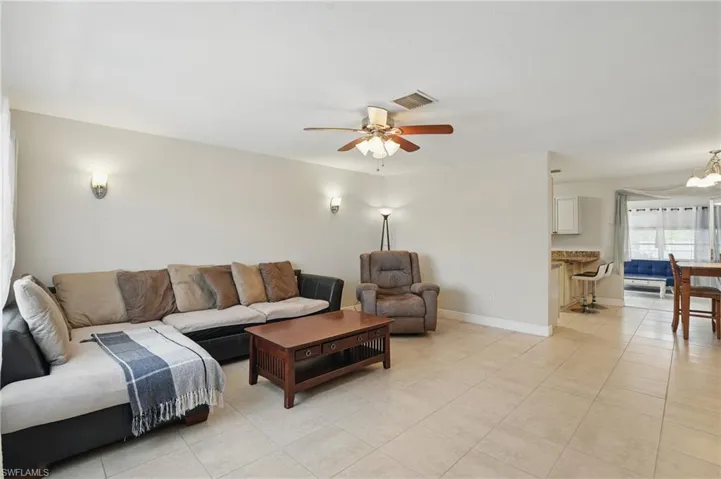 Living room featuring light tile patterned flooring and a ceiling fan