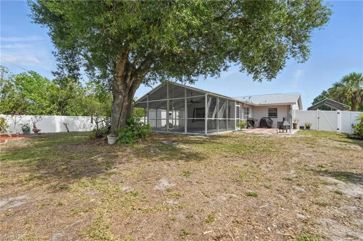 Back of house featuring a fenced backyard, a patio, a gate, a lanai, and a sunroom