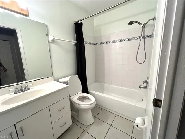 Full bathroom featuring vanity, shower / bath combination with curtain, and light tile patterned floors