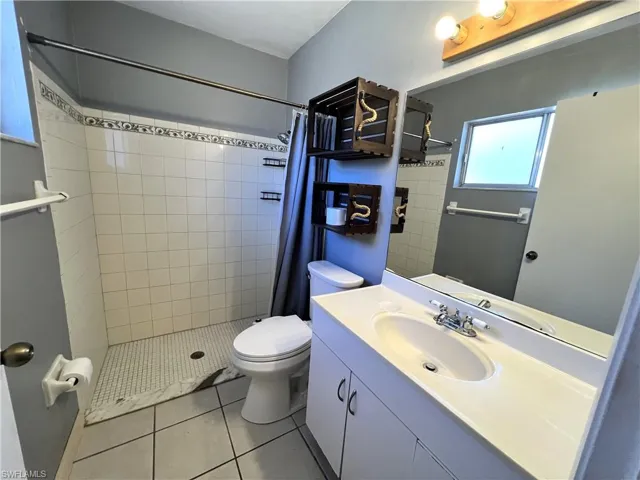 Bathroom featuring vanity, a shower stall, and light tile patterned floors
