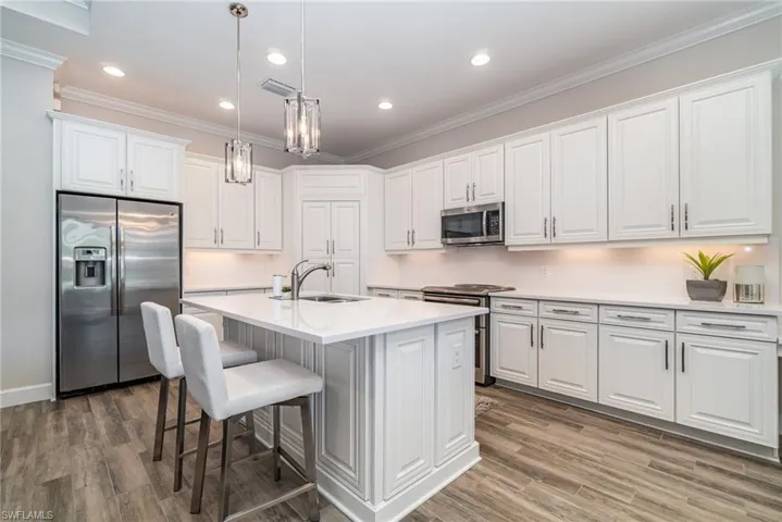 Stylish gourmet kitchen with stainless steel appliances, island and quartz counter tops and backsplash