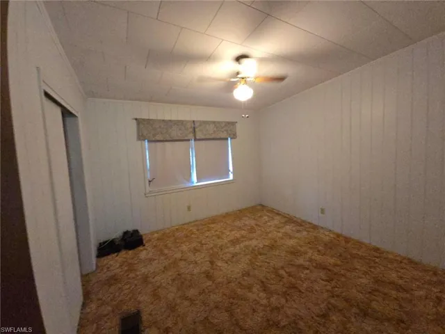 Unfurnished room featuring carpet floors and ceiling fan