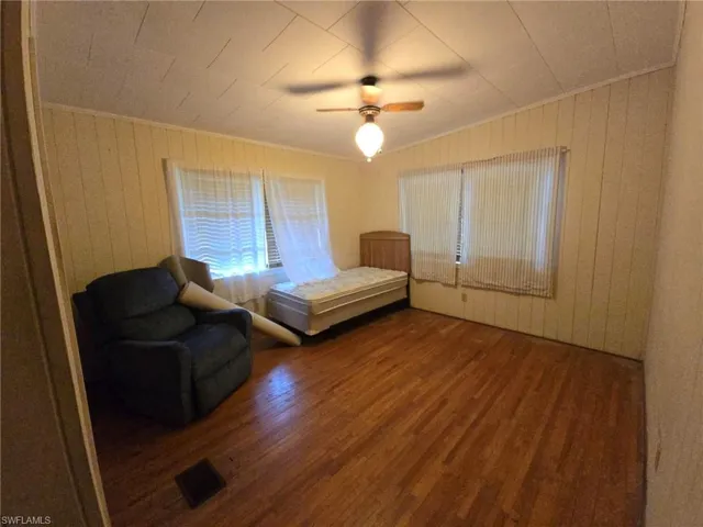 Unfurnished room featuring ceiling fan, wood-type flooring, and ornamental molding