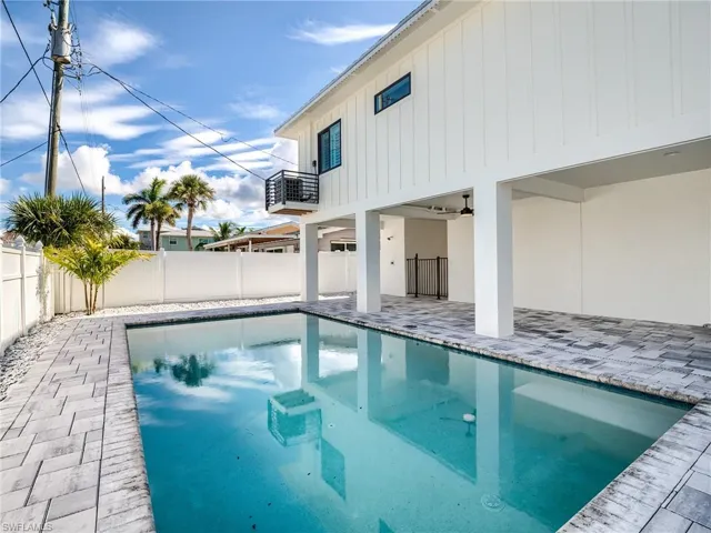 View of swimming pool featuring ceiling fan, central air condition unit, and a patio