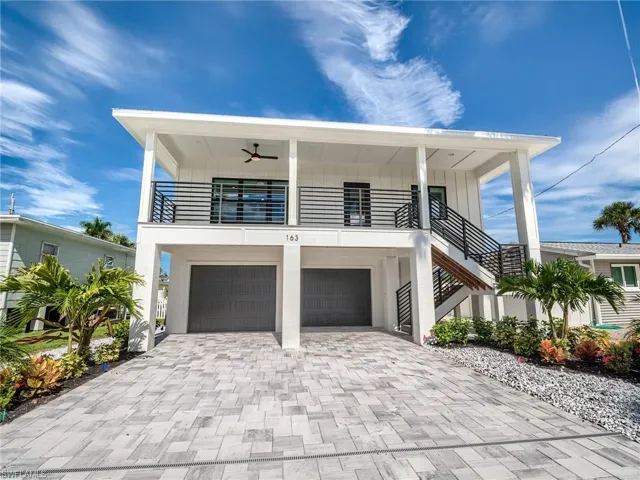View of front of property featuring a garage and ceiling fan