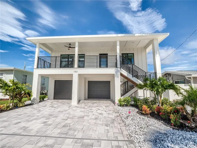 View of front of property featuring a garage and ceiling fan