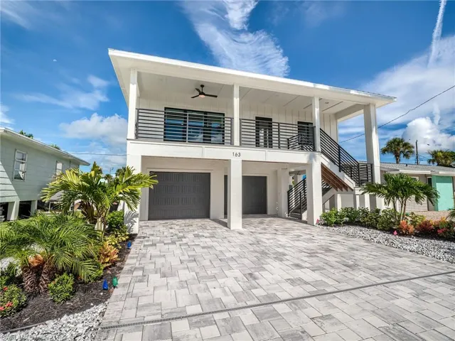 View of front of home with a garage and ceiling fan